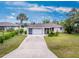 Charming single-story home featuring a two-car garage and a well-manicured front yard with mature trees at 1337 Le Pera Rd, Englewood, FL 34223