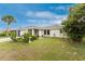 Well-maintained home with a two-car garage, complemented by a lush lawn and attractive landscaping at 1337 Le Pera Rd, Englewood, FL 34223