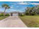 Charming single-Gathering home with a well-manicured lawn, mature trees, and an inviting driveway at 1337 Le Pera Rd, Englewood, FL 34223