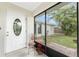 Cozy front porch with decorative chair, potted flowers, and a view of the landscaped front yard at 1337 Le Pera Rd, Englewood, FL 34223