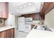 Bright kitchen features wood cabinets, white appliances, tiled floor, and dual stainless steel sink at 1337 Le Pera Rd, Englewood, FL 34223