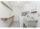 Utility room includes a washer, dryer, utility sink, and shelving for storage at 1337 Le Pera Rd, Englewood, FL 34223