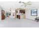 Open floor plan with living and kitchen, showcasing neutral carpet, a ceiling fan, and a view to the front door at 1337 Le Pera Rd, Englewood, FL 34223
