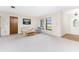Bright living room featuring neutral carpet, comfortable seating, and natural light from large windows at 1337 Le Pera Rd, Englewood, FL 34223