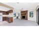 Open living space featuring a stone fireplace, kitchen cabinets, and bright windows at 1337 Le Pera Rd, Englewood, FL 34223