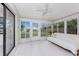 Enclosed sunroom with tile flooring, large windows providing serene views of the backyard at 1337 Le Pera Rd, Englewood, FL 34223