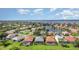 Stunning aerial view of a beautiful residential community with a lake backdrop and colorful tiled roofs at 13376 Golf Pointe Dr, Port Charlotte, FL 33953