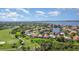Gorgeous aerial view showcases a community near a golf course, a body of water, and vibrant green spaces at 13376 Golf Pointe Dr, Port Charlotte, FL 33953