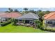 Aerial view of a home's screened lanai, lush landscaping, and well-manicured lawn at 13376 Golf Pointe Dr, Port Charlotte, FL 33953