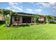 Beautiful backyard featuring a screened-in patio, lush landscaping, and well-maintained lawn at 13376 Golf Pointe Dr, Port Charlotte, FL 33953
