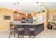 An eat-in kitchen features granite counters, wood cabinetry, stainless appliances, pendant lighting, and bar seating at 13376 Golf Pointe Dr, Port Charlotte, FL 33953