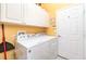 The laundry room has a full-size washer and dryer, storage cabinetry and a door to an adjoining room at 13376 Golf Pointe Dr, Port Charlotte, FL 33953