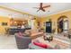 Open-concept living room with tile flooring, ceiling fan, and seamless flow to the kitchen at 13376 Golf Pointe Dr, Port Charlotte, FL 33953