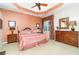 The main bedroom has a tray ceiling, ceiling fan, carpet flooring, and large window at 13376 Golf Pointe Dr, Port Charlotte, FL 33953