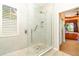 The bathroom features a glass enclosed shower with white tile and a view of the main bedroom at 13376 Golf Pointe Dr, Port Charlotte, FL 33953