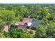 Bird's-eye view of large home surrounded by mature trees, shed, and screened-in pool area at 1550 Bayshore Dr, Englewood, FL 34223