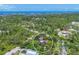 Beautiful aerial view of a home nestled among lush trees, showcasing its privacy and proximity to the water at 1550 Bayshore Dr, Englewood, FL 34223