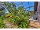 Lush backyard landscaping with unique bird sculpture, outdoor grill, and stone walkway at 1550 Bayshore Dr, Englewood, FL 34223