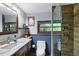Bathroom with vanity sink, marble countertops, wood paneling, and glass shower with wood-look shower tile at 1550 Bayshore Dr, Englewood, FL 34223