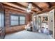 Bedroom with wood walls, exposed beams, and an open bathroom with a modern vanity sink at 1550 Bayshore Dr, Englewood, FL 34223