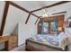 Bedroom featuring wood beams, wood walls, a window with blue curtains, desk, and bed with blue quilt at 1550 Bayshore Dr, Englewood, FL 34223
