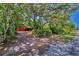 A long brick driveway leads to the house, nestled among lush trees and greenery at 1550 Bayshore Dr, Englewood, FL 34223