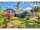 Spacious backyard with a screened pool area, mature trees, and lush landscaping, house on left at 1550 Bayshore Dr, Englewood, FL 34223
