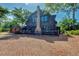 Log home featuring a stone chimney and a brick driveway, surrounded by lush landscaping at 1550 Bayshore Dr, Englewood, FL 34223