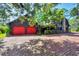Inviting home with a brick driveway, red garage doors, and a striking stone chimney at 1550 Bayshore Dr, Englewood, FL 34223