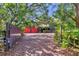 Beautiful log home with a brick driveway, mature trees, and a charming fence at 1550 Bayshore Dr, Englewood, FL 34223