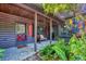 Cozy log cabin porch with a bench, ferns, and a charming entrance at 1550 Bayshore Dr, Englewood, FL 34223