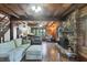 Cozy living room featuring a stone fireplace, hardwood floors, and exposed wood beams at 1550 Bayshore Dr, Englewood, FL 34223