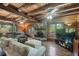 Cozy living room with wood paneling, beamed ceilings, a stone fireplace, and comfortable furniture at 1550 Bayshore Dr, Englewood, FL 34223