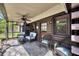 Relaxing screened porch with stone flooring, ceiling fan and comfortable wicker furniture at 1550 Bayshore Dr, Englewood, FL 34223