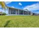 Well-maintained backyard featuring a spacious screened-in patio and lush green lawn at 15610 Staunton Cir, Port Charlotte, FL 33981