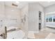 Spa bathroom boasting a soaking tub, tiled walls, and a large shower with modern fixtures at 15610 Staunton Cir, Port Charlotte, FL 33981