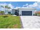 Beautiful single-story home with a lush green lawn, stone accents, and a gray paved driveway at 15610 Staunton Cir, Port Charlotte, FL 33981