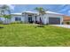 Beautiful single-story home with a lush green lawn, stone accents, and a gray paved driveway at 15610 Staunton Cir, Port Charlotte, FL 33981