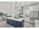 Bright, open kitchen with white cabinets, island with marble countertop, and stainless steel appliances at 15610 Staunton Cir, Port Charlotte, FL 33981