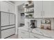 Charming coffee bar area with open shelving, modern appliances, and luxurious marble countertops at 15610 Staunton Cir, Port Charlotte, FL 33981