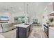 Open kitchen with marble countertop island, white cabinets and stainless appliances, and open to living and dining areas at 15610 Staunton Cir, Port Charlotte, FL 33981