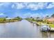 Scenic view of a waterfront canal with boats docked at homes under a blue, partly cloudy sky at 15610 Staunton Cir, Port Charlotte, FL 33981