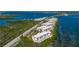 Stunning aerial view of waterfront condos with private balconies and lush greenery along the shoreline near the bridge at 1591 Beach Rd # 402, Englewood, FL 34223