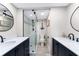 Well lit bathroom with a double sink vanity and a glass door shower with tasteful decorations at 1591 Beach Rd # 402, Englewood, FL 34223