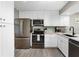 Updated kitchen features stainless steel appliances, white cabinets and light backsplash at 1591 Beach Rd # 402, Englewood, FL 34223