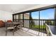 Enclosed lanai with water views features tiled floors, a ceiling fan, and a table with seating at 1591 Beach Rd # 402, Englewood, FL 34223