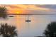 Waterfront property with stunning sunset view overlooking bay with sailboat, palm trees in foreground framing the scenery at 1591 Beach Rd # 402, Englewood, FL 34223