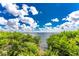Scenic water view through the trees, with a vibrant blue sky with puffy white clouds at 1591 Beach Rd # 402, Englewood, FL 34223