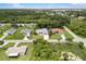 An aerial view displays a charming single-Gathering home surrounded by lush green trees and landscaping at 18112 Windswept Av, Port Charlotte, FL 33948