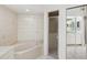 A bright bathroom is well-appointed with tile floors, a soaking tub, and a separate shower at 18112 Windswept Av, Port Charlotte, FL 33948